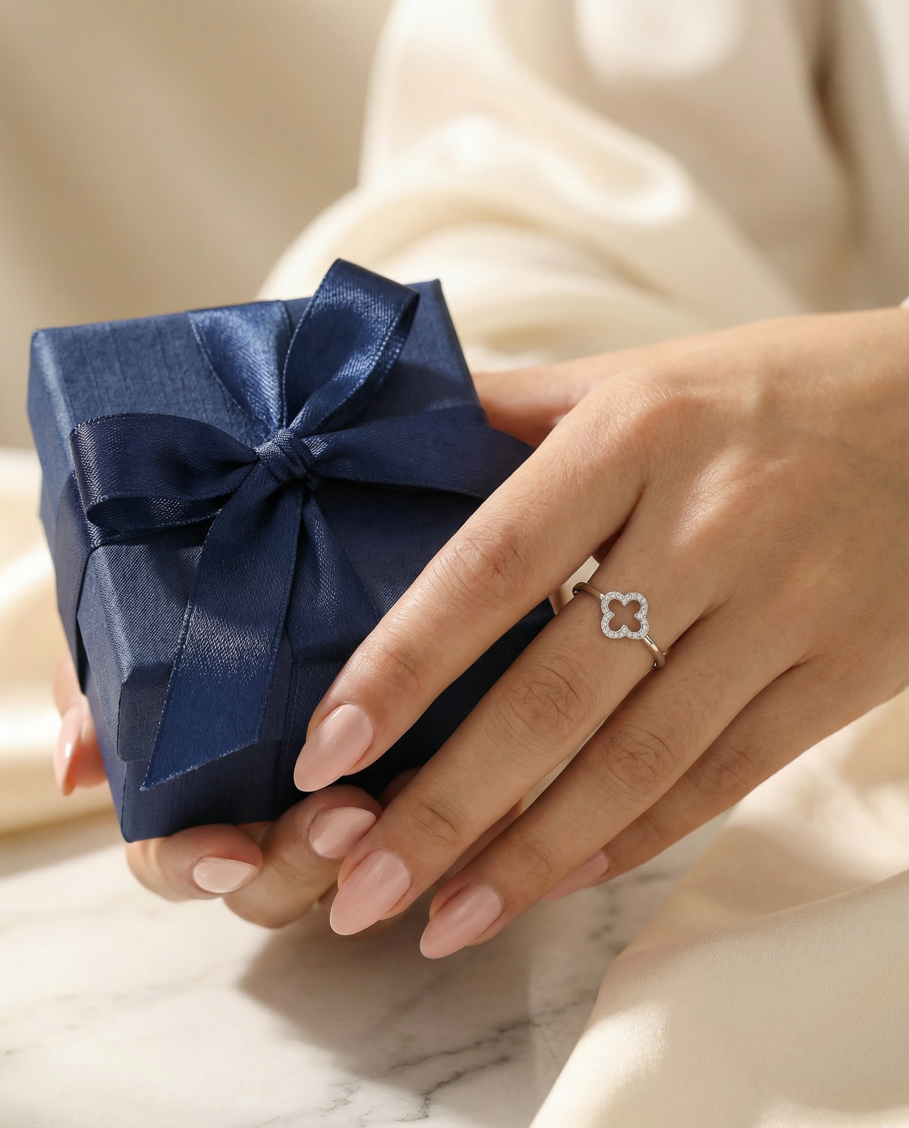 Bague Trèfle — Main tenant une boîte cadeau navy blue, concept cadeau