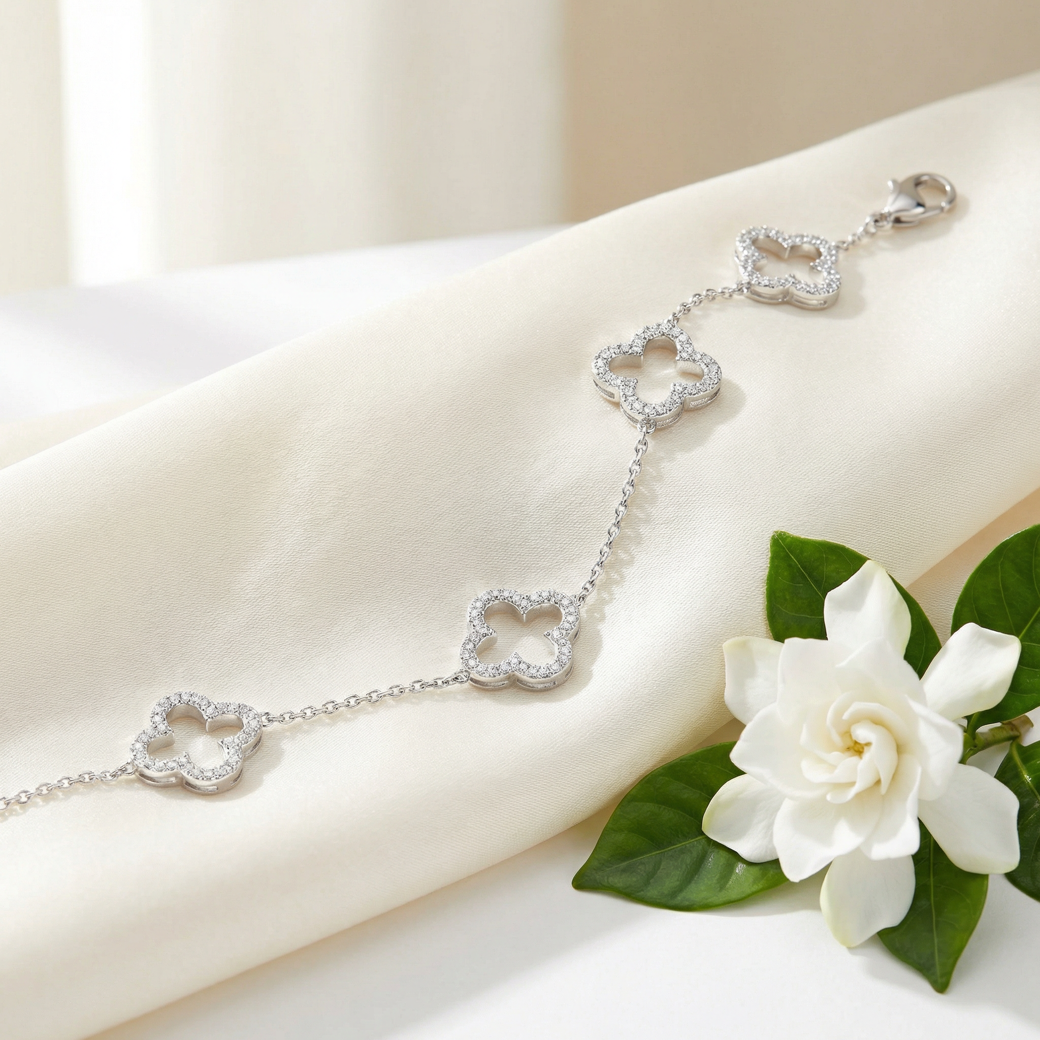 Bracelet Trèfle — Argent et Diamants — mise en scène sur soie ivoire avec gardénia